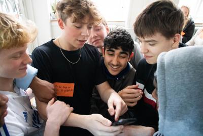 Fire skoleelever kigger på en telefon