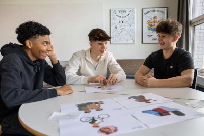 Tre skoleelever løser opgave ved et bord