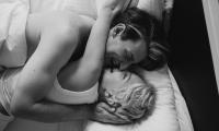 Par i sengen griner og kysser