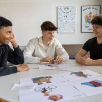 Tre skoleelever løser opgave ved et bord
